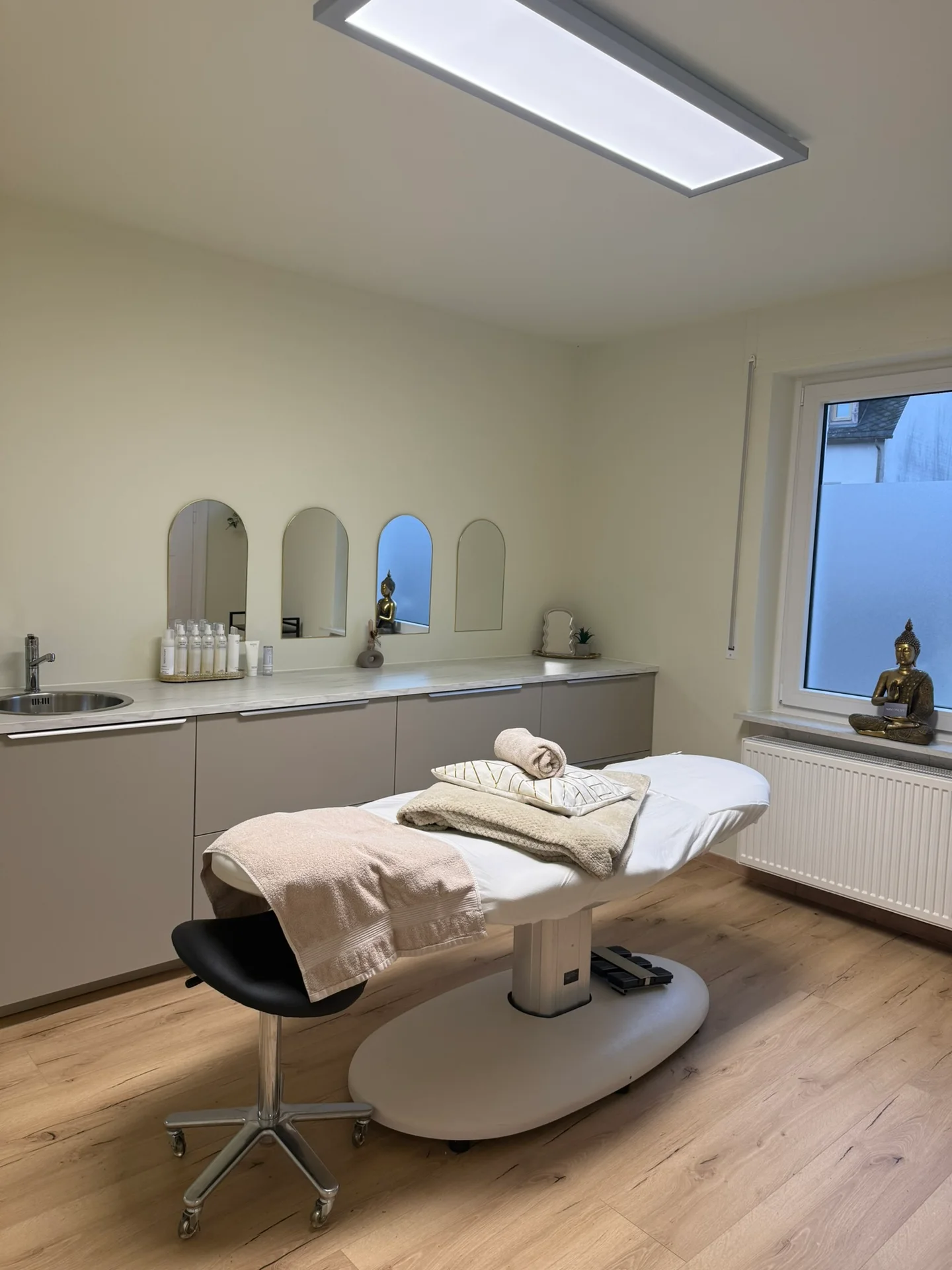 Einblick in das Skinconcept Institut mit Behandlungsliege, Pflegeregal und Fenster